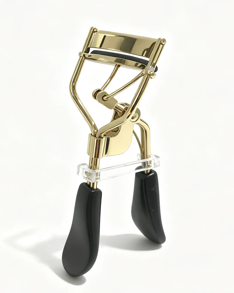 Gold-tone metal eyelash curler with black handles